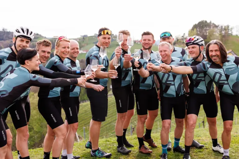 TeilnehmerInnen von Woamfoahn stoßen auf den Rennradauftakt in der Südsteiermark mit einem Glas Wein an.