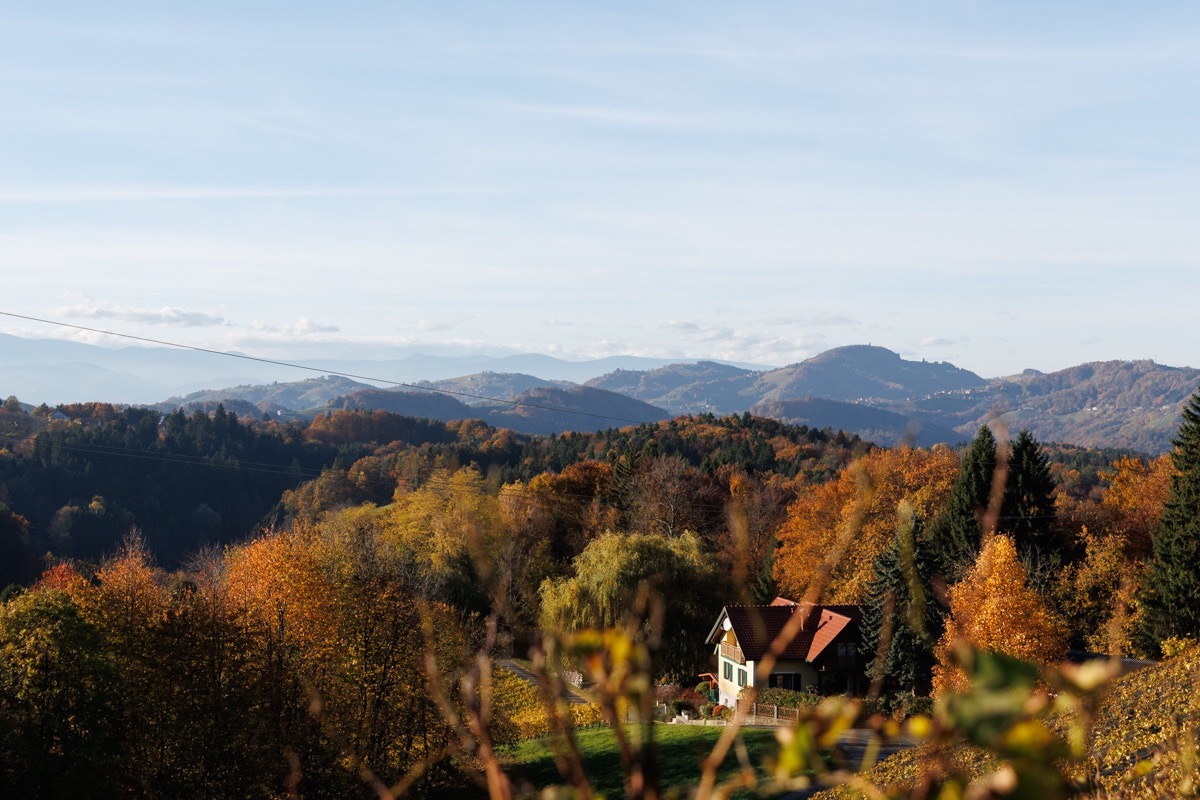 Haus in herbstlicher Berg-Landschaft
